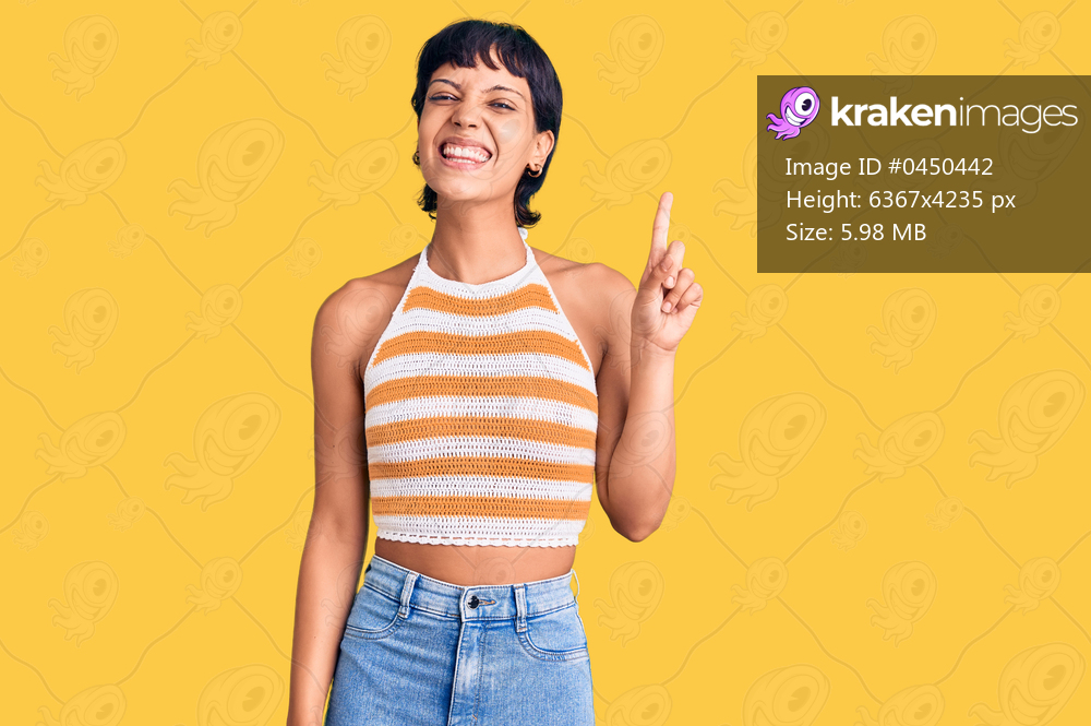 Young brunette woman with short hair wearing casual clothes showing and pointing up with finger number one while smiling confident and happy. 