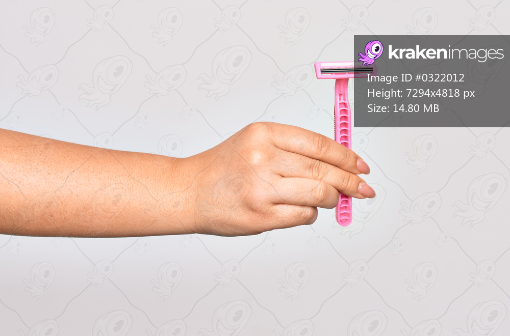 Hand of caucasian young woman holding pink razor over isolated white background