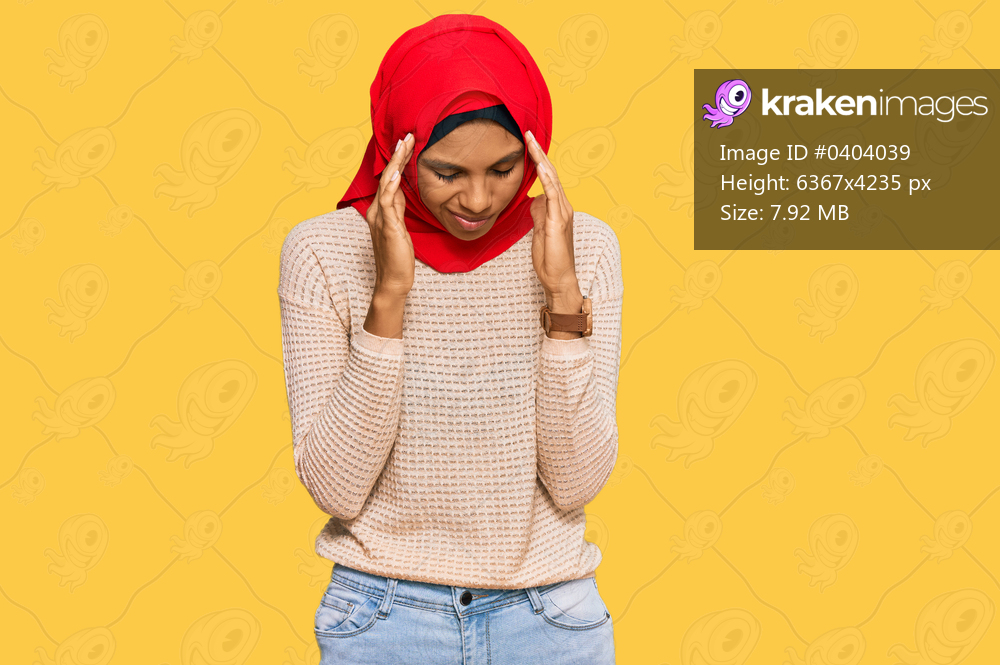 Young african american woman wearing traditional islamic hijab scarf with hand on head, headache because stress. suffering migraine. 