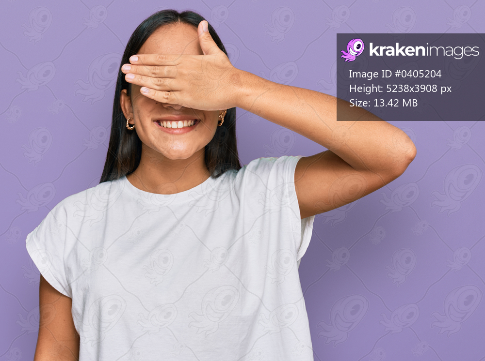 Young asian woman wearing casual white t shirt smiling and laughing with hand on face covering eyes for surprise. blind concept. 