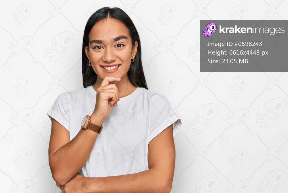 Young asian woman wearing casual white t shirt looking confident at the camera with smile with crossed arms and hand raised on chin. thinking positive. 