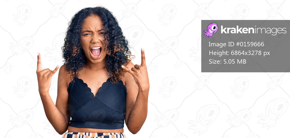 Young african american woman wearing casual clothes shouting with crazy expression doing rock symbol with hands up. music star. heavy concept. 