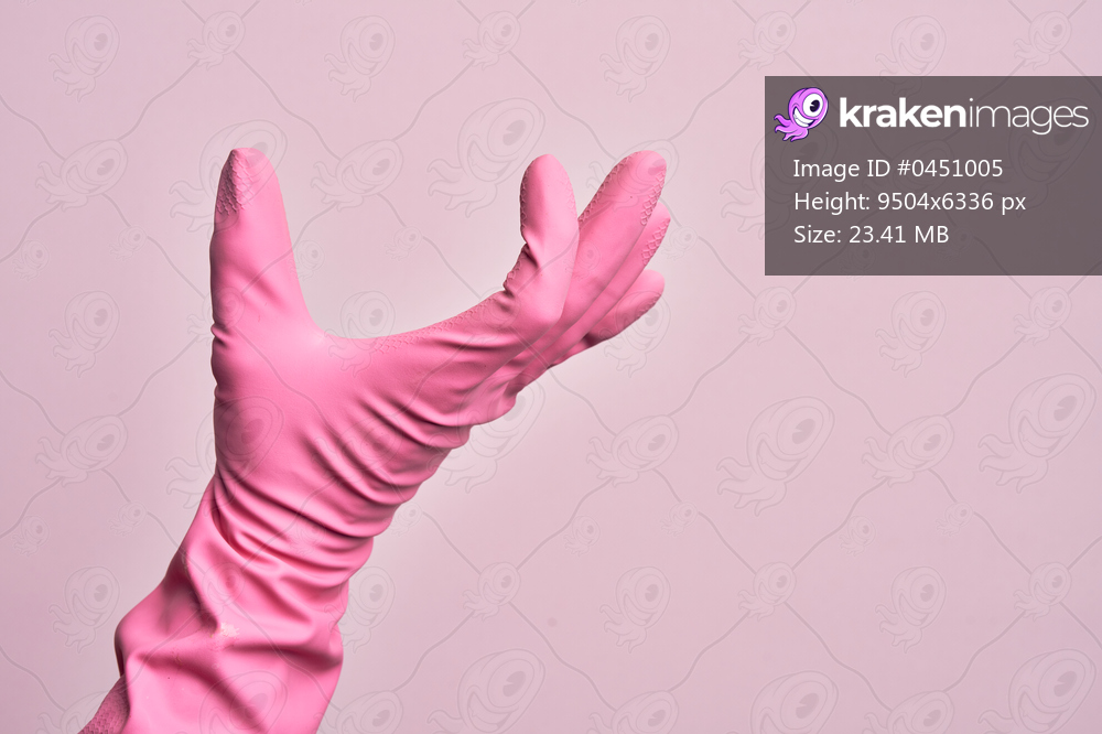 Hand of caucasian young man with cleaning glove over isolated pink background picking and taking invisible thing, holding object with fingers showing space