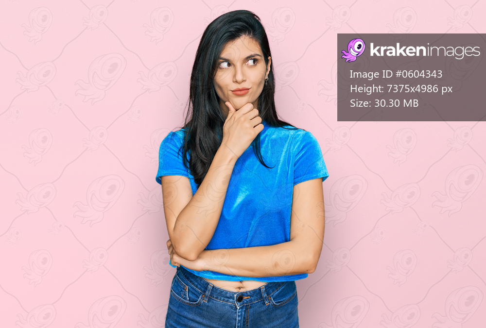 Young hispanic woman wearing casual clothes with hand on chin thinking about question, pensive expression. smiling with thoughtful face. doubt concept. 