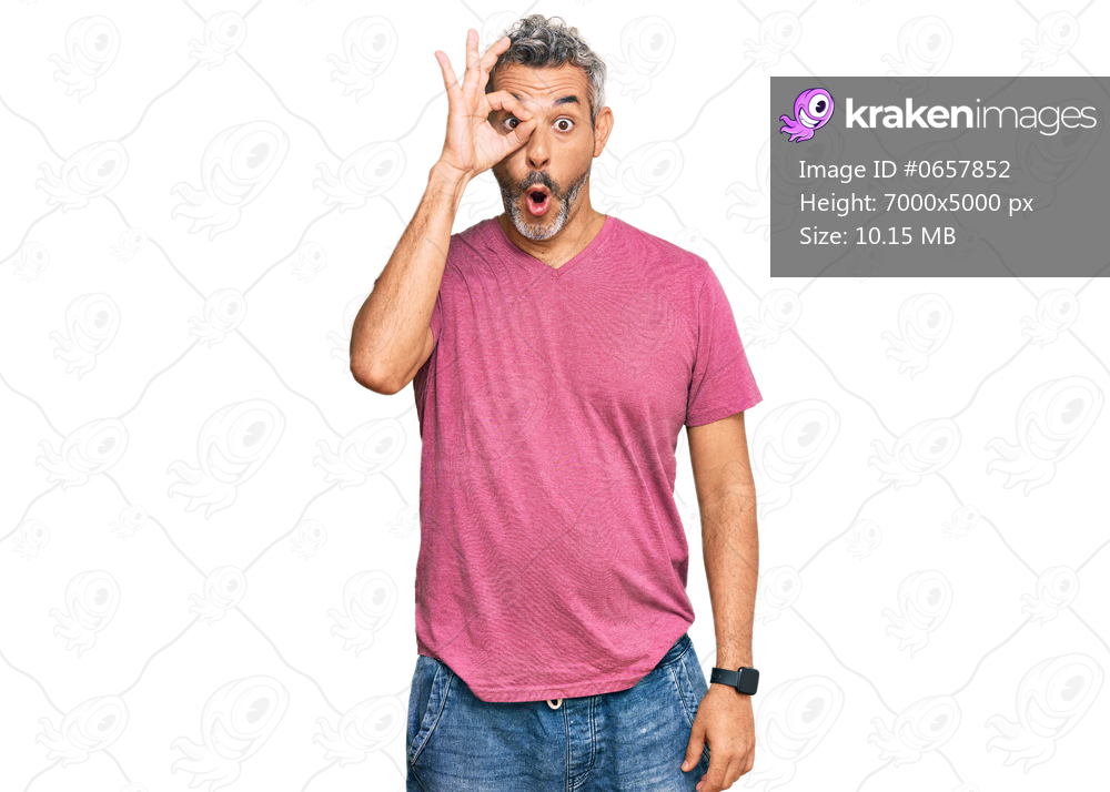 Middle age grey-haired man wearing casual clothes doing ok gesture shocked with surprised face, eye looking through fingers. unbelieving expression. 
