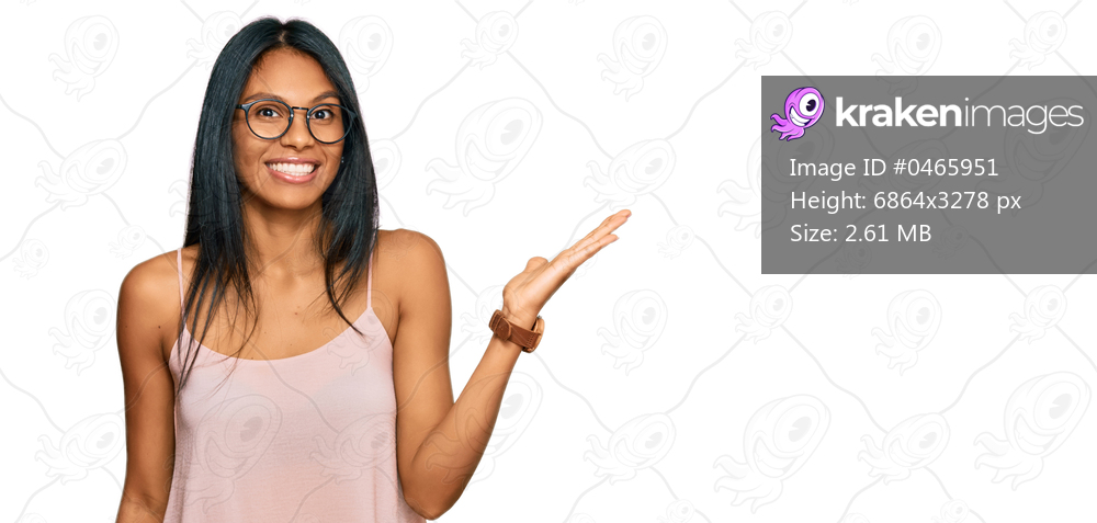 Young african american woman wearing casual clothes and glasses smiling cheerful presenting and pointing with palm of hand looking at the camera. 