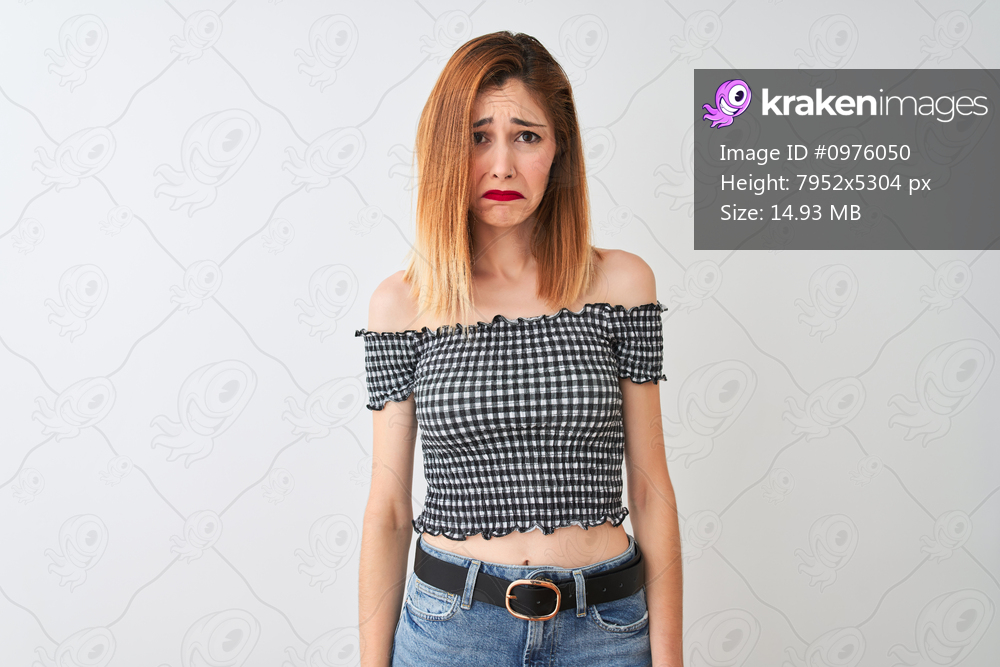Beautiful redhead woman wearing casual t-shirt standing over isolated white background depressed and worry for distress, crying angry and afraid. Sad expression.