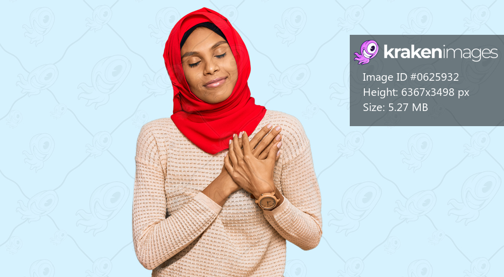 Young african american woman wearing traditional islamic hijab scarf smiling with hands on chest with closed eyes and grateful gesture on face. health concept. 