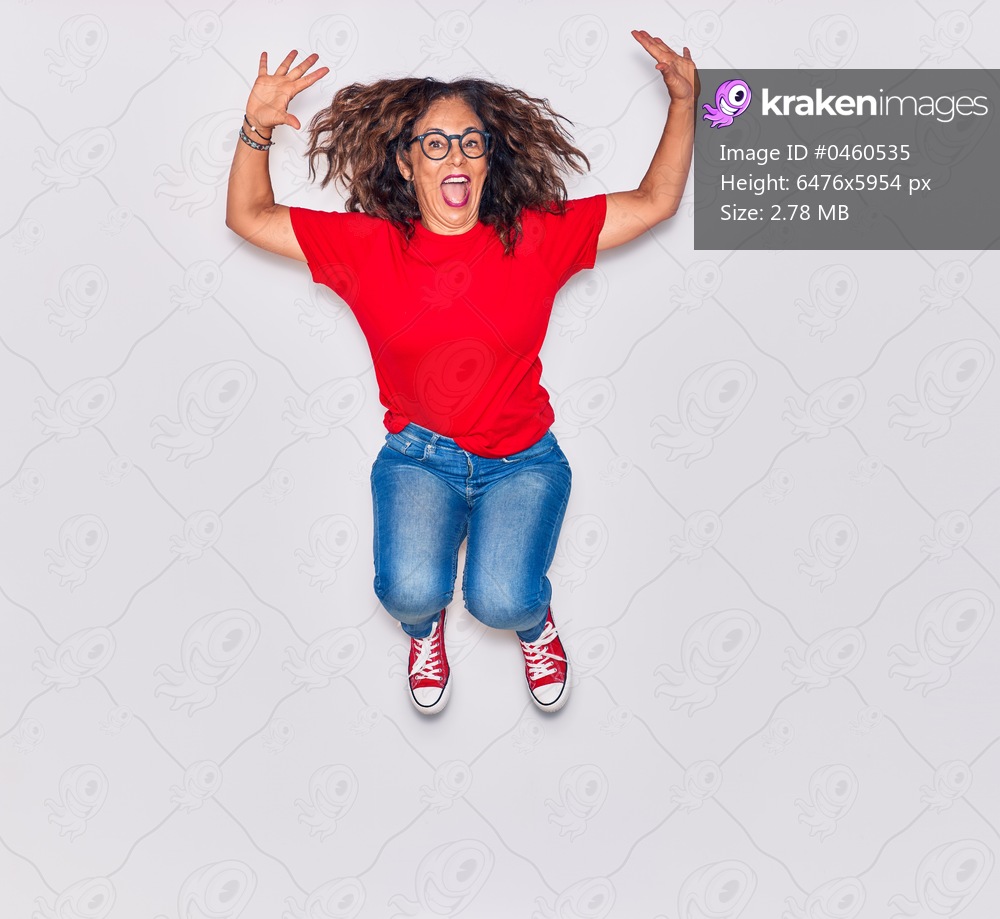 Middle age beautiful hispanic woman wearing casual clothes and glasses smiling happy. Jumping with smile on face over isolated white background