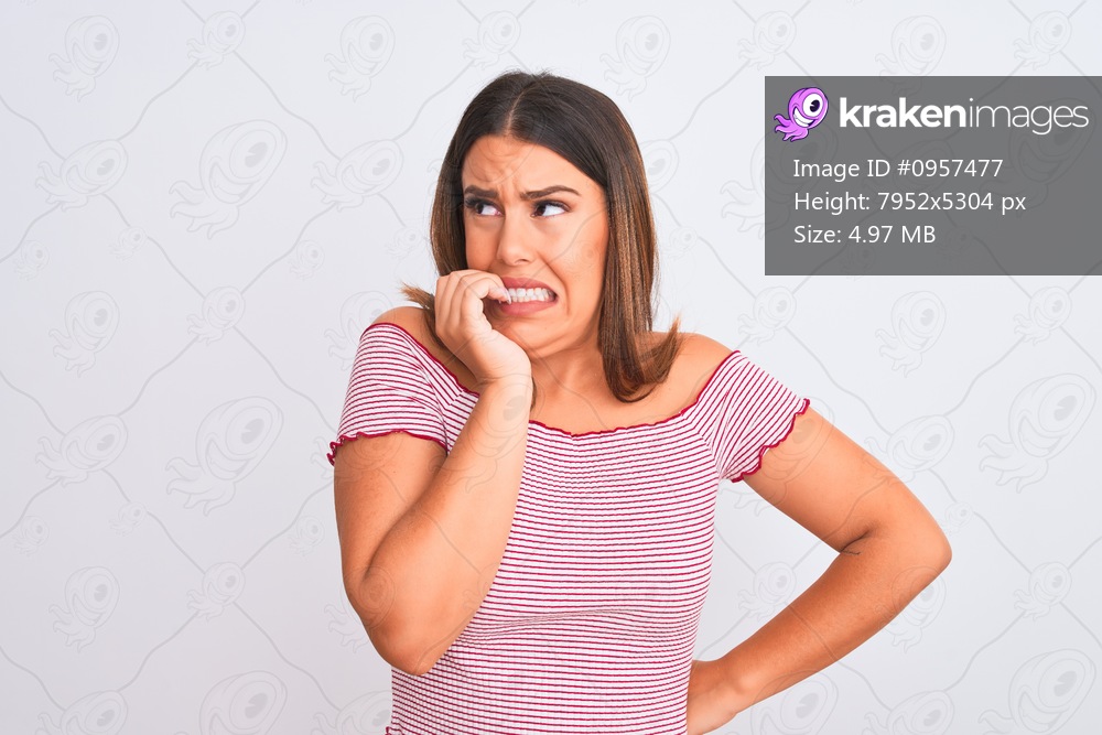 Portrait of beautiful young woman standing over isolated white background looking stressed and nervous with hands on mouth biting nails. Anxiety problem.