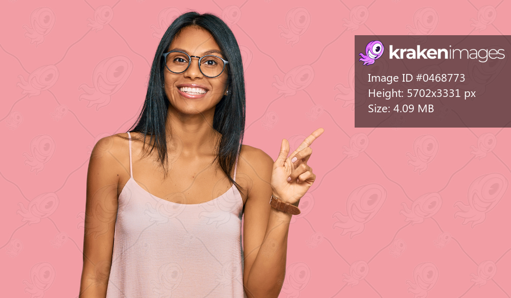 Young african american woman wearing casual clothes and glasses with a big smile on face, pointing with hand finger to the side looking at the camera. 