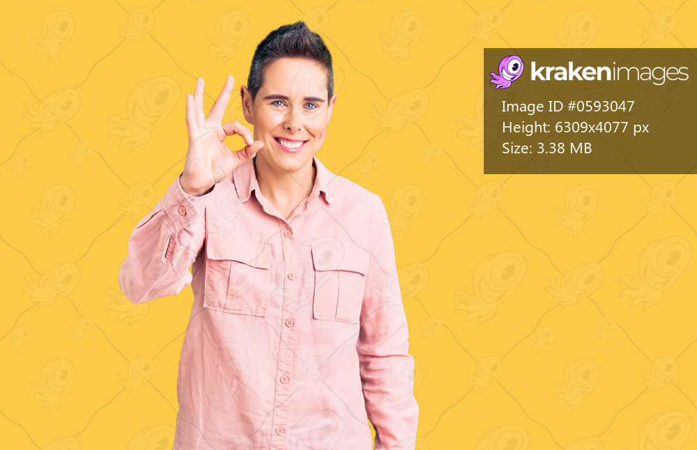 Young woman with short hair wearing casual clothes smiling positive doing ok sign with hand and fingers. successful expression. 