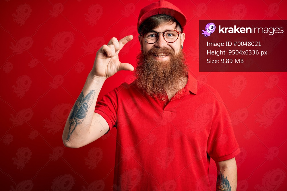 Young handsome delivery man wearing glasses and red cap over isolated background smiling and confident gesturing with hand doing small size sign with fingers looking and the camera. Measure concept.