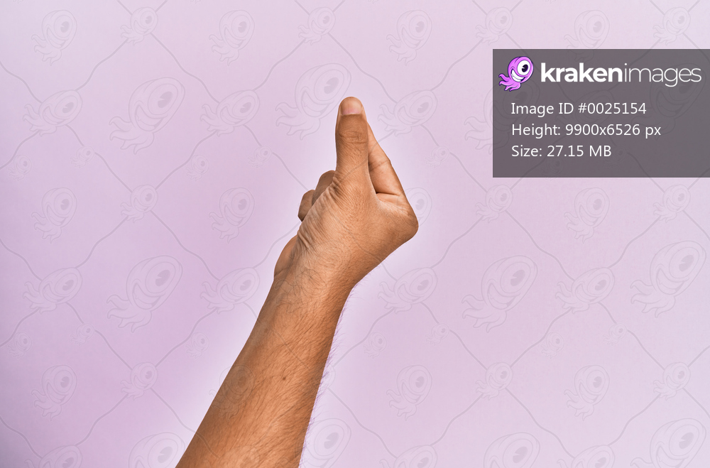 Arm and hand of caucasian young man over pink isolated background holding blank space with thumb finger, business and advertising 