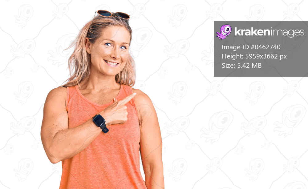 Middle age fit blonde woman wearing casual summer clothes and sunglasses cheerful with a smile on face pointing with hand and finger up to the side with happy and natural expression 