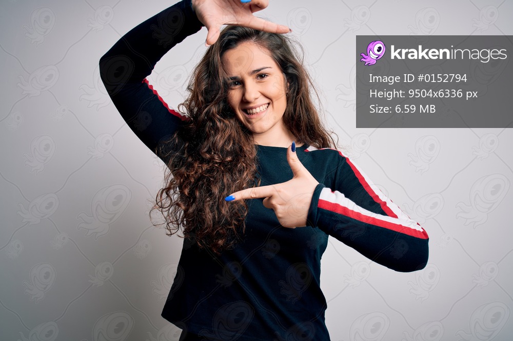 Young beautiful woman with curly hair wearing casual sweater over isolated white background smiling making frame with hands and fingers with happy face. Creativity and photography concept.