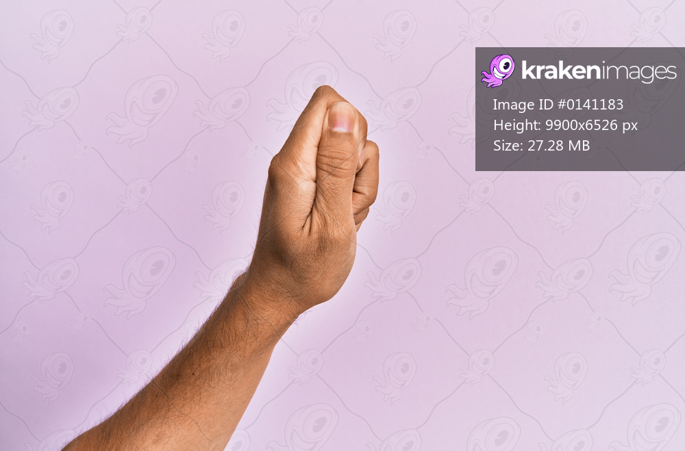 Arm and hand of caucasian young man over pink isolated background holding blank space with thumb finger, business and advertising 
