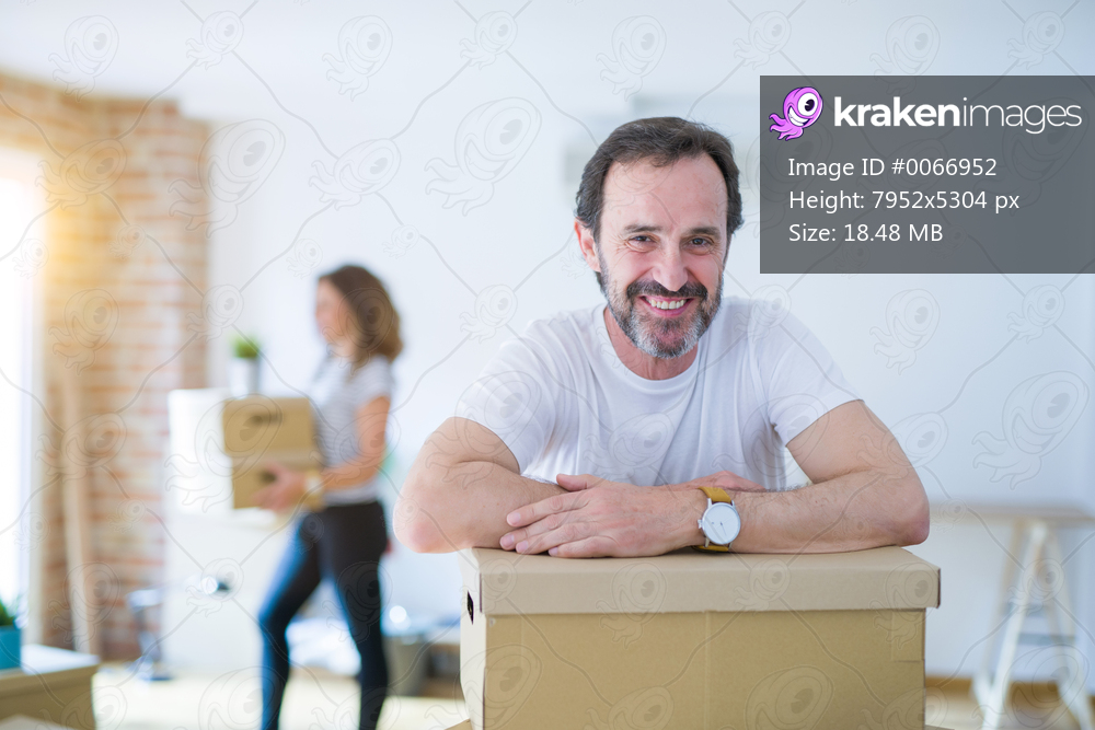 Middle age senior couple moving to a new house, man smiling happy in love with new apartment