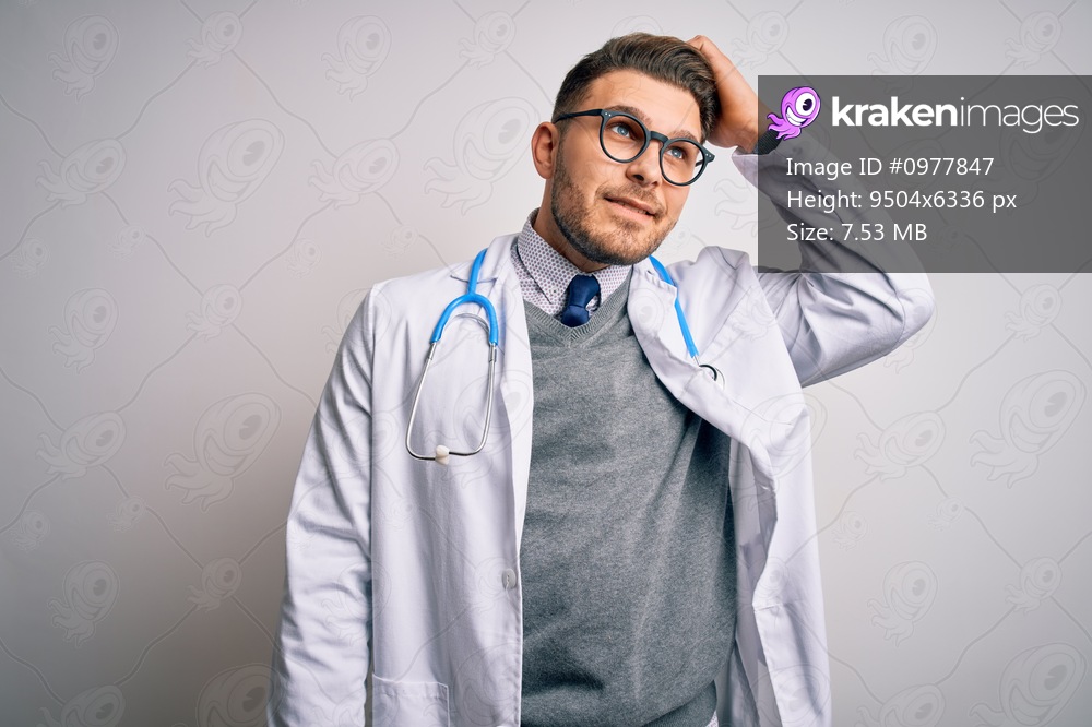 Young doctor man with blue eyes wearing medical coat and stethoscope over isolated background smiling confident touching hair with hand up gesture, posing attractive and fashionable