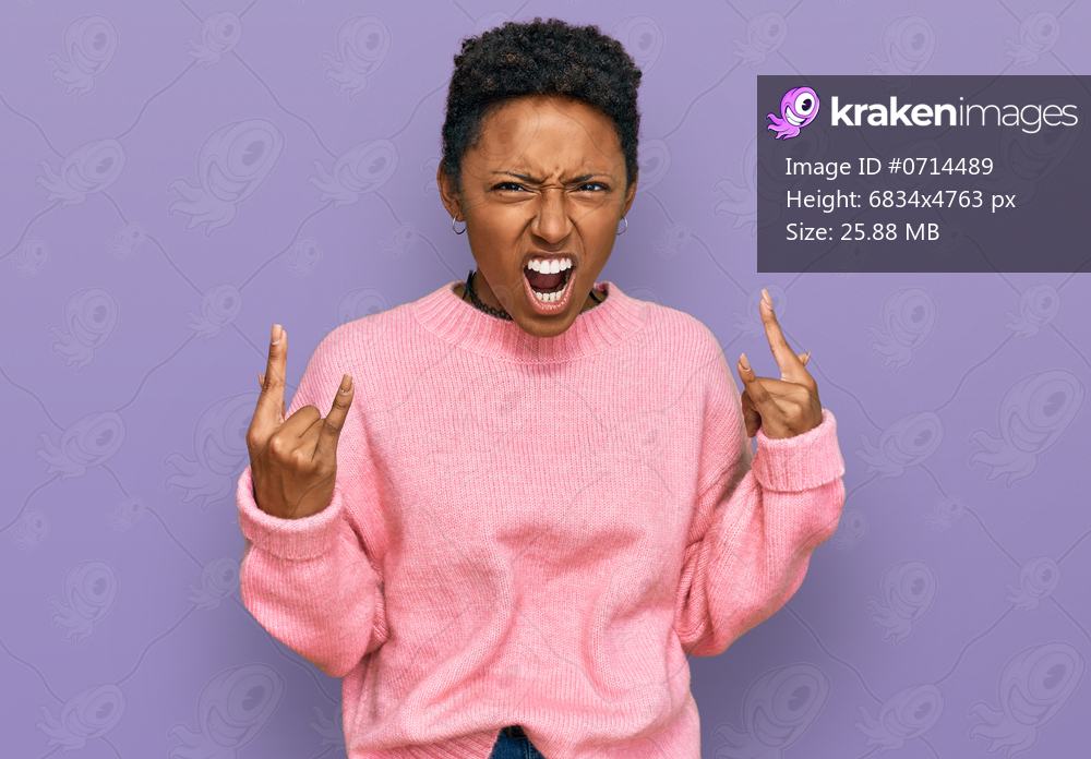 Young african american woman wearing casual clothes shouting with crazy expression doing rock symbol with hands up. music star. heavy concept. 