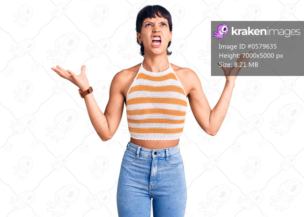 Young brunette woman with short hair wearing casual clothes crazy and mad shouting and yelling with aggressive expression and arms raised. frustration concept. 