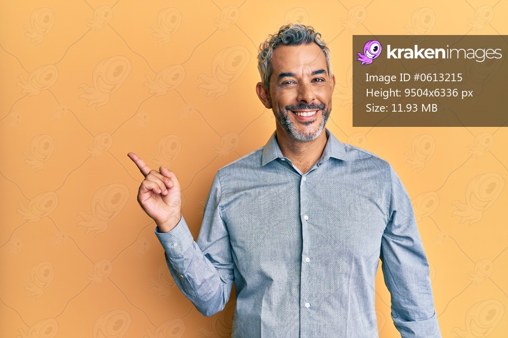 Middle age grey-haired man wearing casual clothes smiling happy pointing with hand and finger to the side 