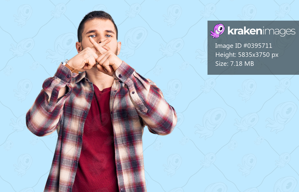 Young handsome man wearing casual shirt rejection expression crossing fingers doing negative sign 