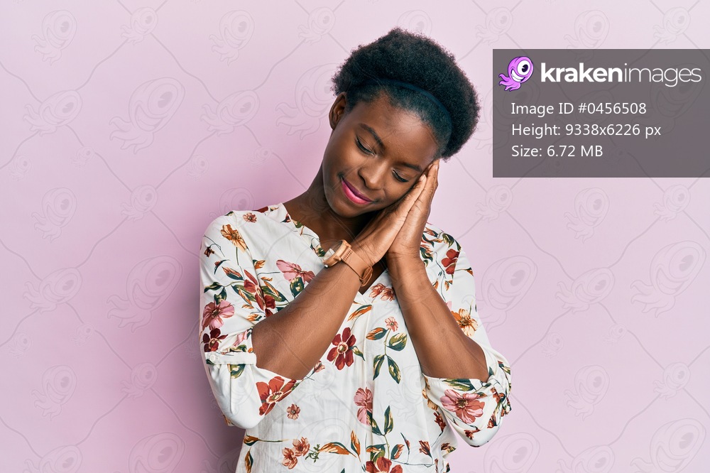Young african american girl wearing casual clothes sleeping tired dreaming and posing with hands together while smiling with closed eyes. 