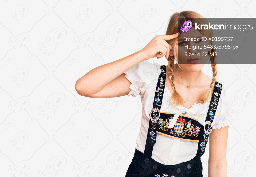 Young beautiful blonde woman wearing oktoberfest dress pointing unhappy to pimple on forehead, ugly infection of blackhead. acne and skin problem 