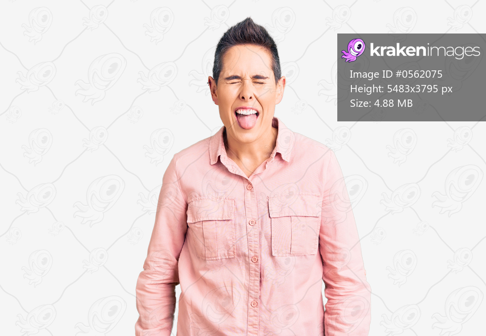 Young woman with short hair wearing casual clothes sticking tongue out happy with funny expression. emotion concept. 