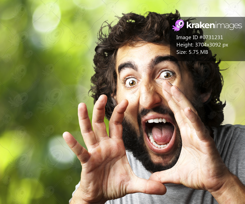 portrait of young man screaming against a nature background