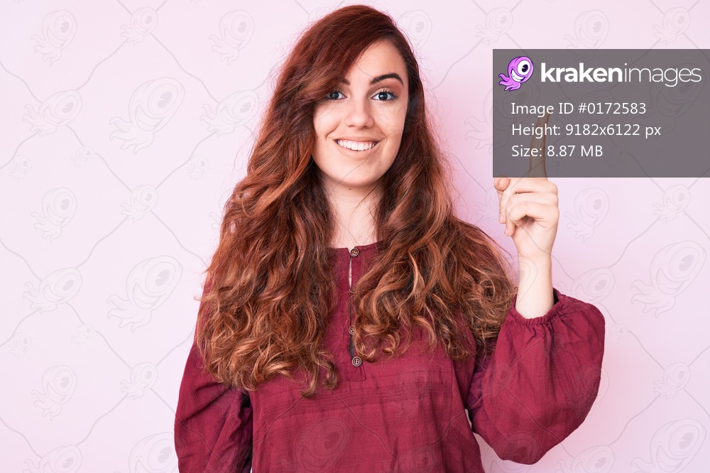 Young beautiful woman wearing casual winter sweater pointing finger up with successful idea. exited and happy. number one. 