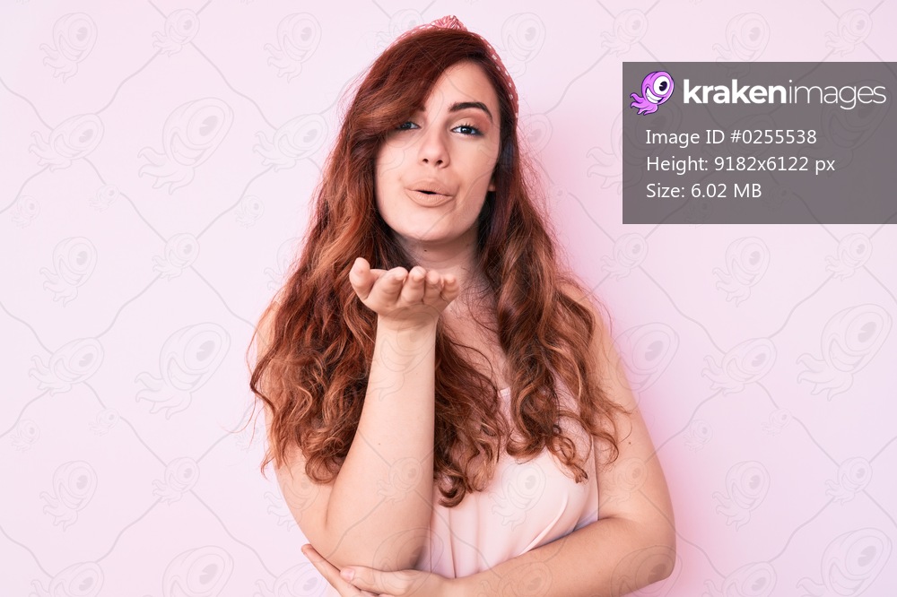 Young beautiful woman wearing casual clothes looking at the camera blowing a kiss with hand on air being lovely and sexy. love expression. 