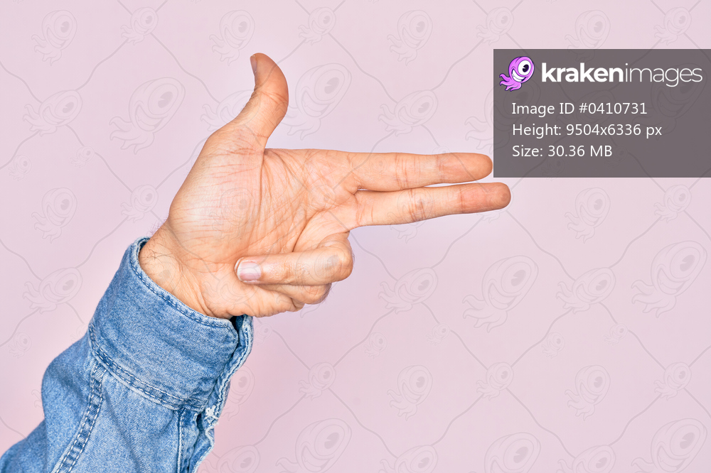 Hand of caucasian young man showing fingers over isolated pink background gesturing fire gun weapon with fingers, aiming shoot symbol