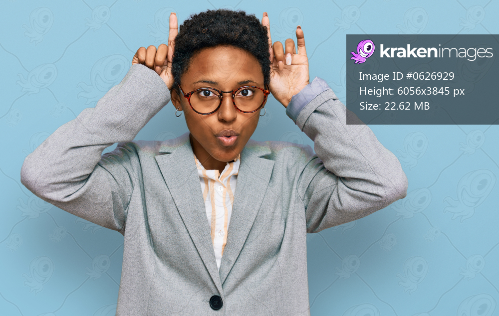 Young african american woman wearing business clothes doing funny gesture with finger over head as bull horns 