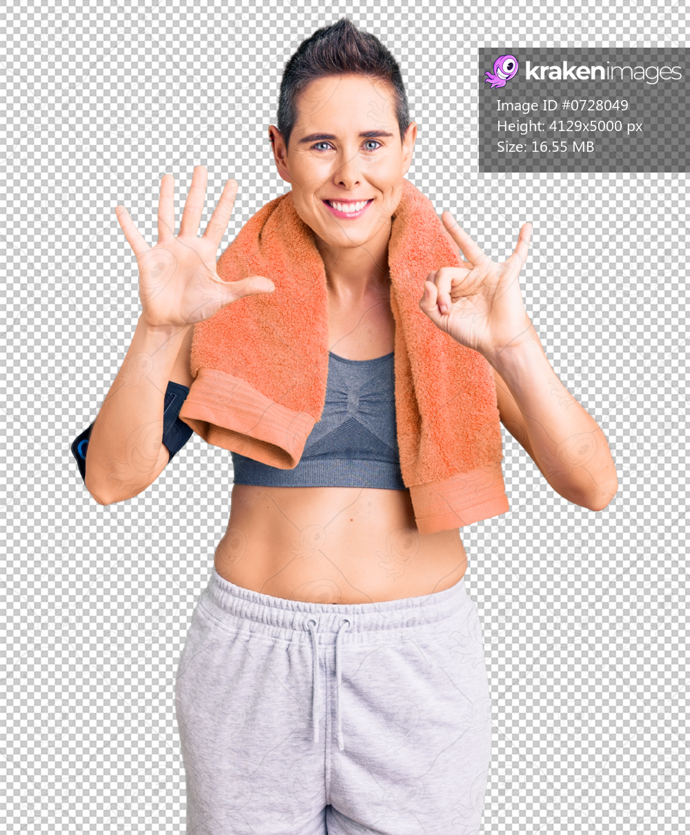 Young woman with short hair wearing sportswear and towel using smartphone showing and pointing up with fingers number seven while smiling confident and happy.