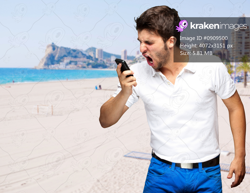 portrait of young man arguing against a beach