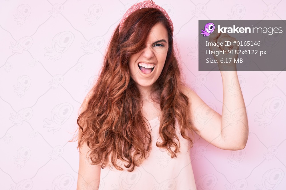 Young beautiful woman wearing casual clothes angry and mad raising fist frustrated and furious while shouting with anger. rage and aggressive concept. 
