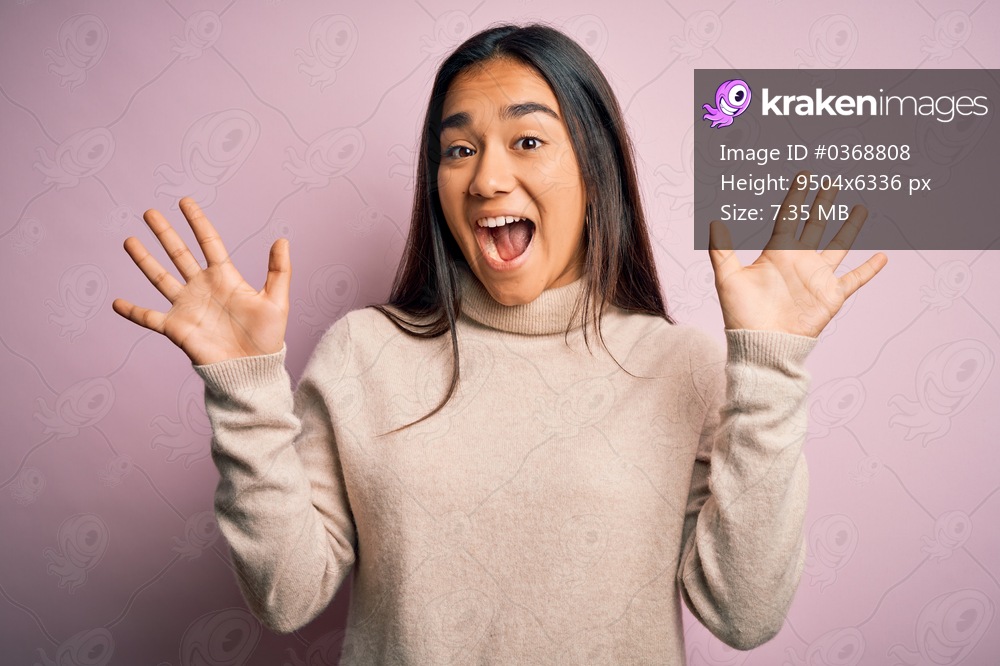 Young beautiful asian woman wearing casual turtleneck sweater over pink background showing and pointing up with fingers number ten while smiling confident and happy.