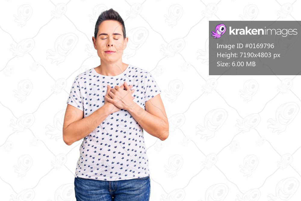 Young woman with short hair wearing casual clothes smiling with hands on chest with closed eyes and grateful gesture on face. health concept. 