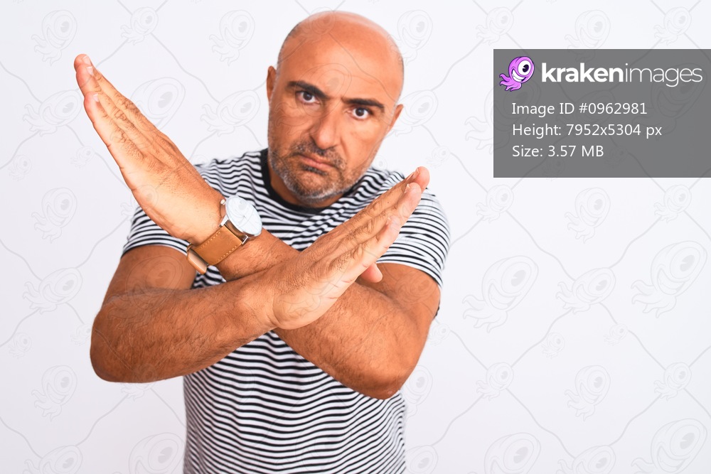 Middle age handsome man wearing striped navy t-shirt over isolated white background Rejection expression crossing arms doing negative sign, angry face