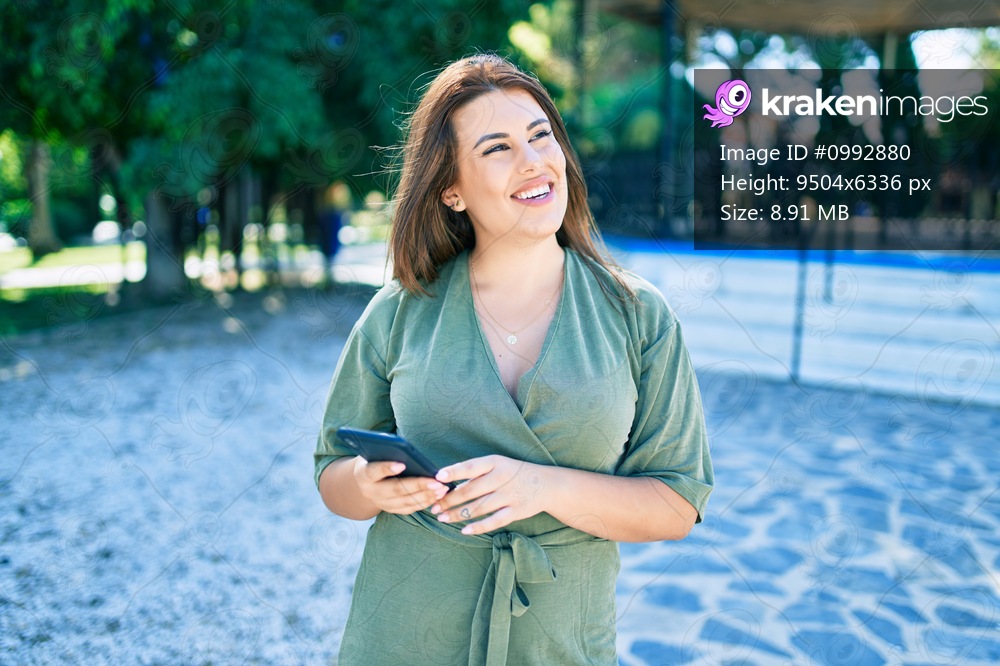 Young hispanic woman smiling happy using smartphone walking at street of city