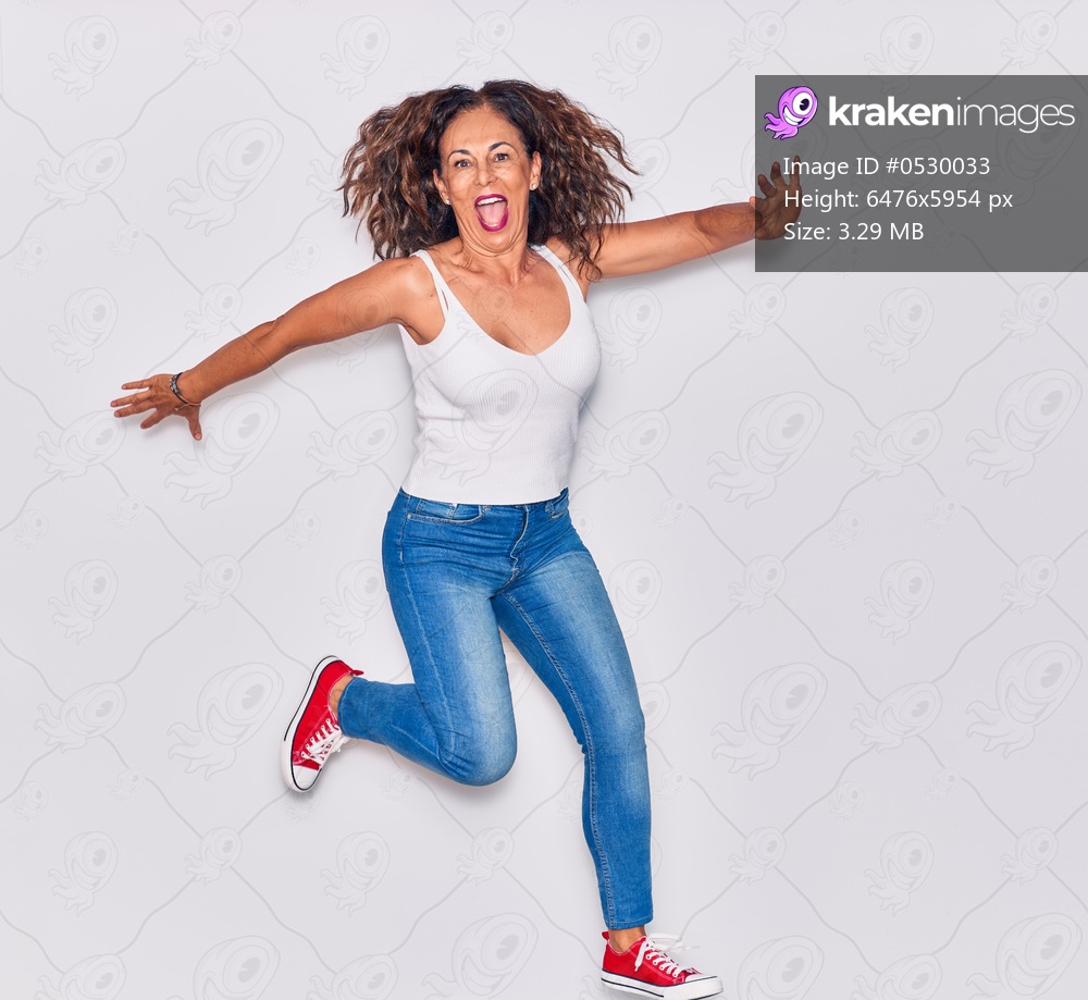 Middle age beautiful hispanic woman wearing casual clothes smiling happy. Jumping with smile on face over isolated white background