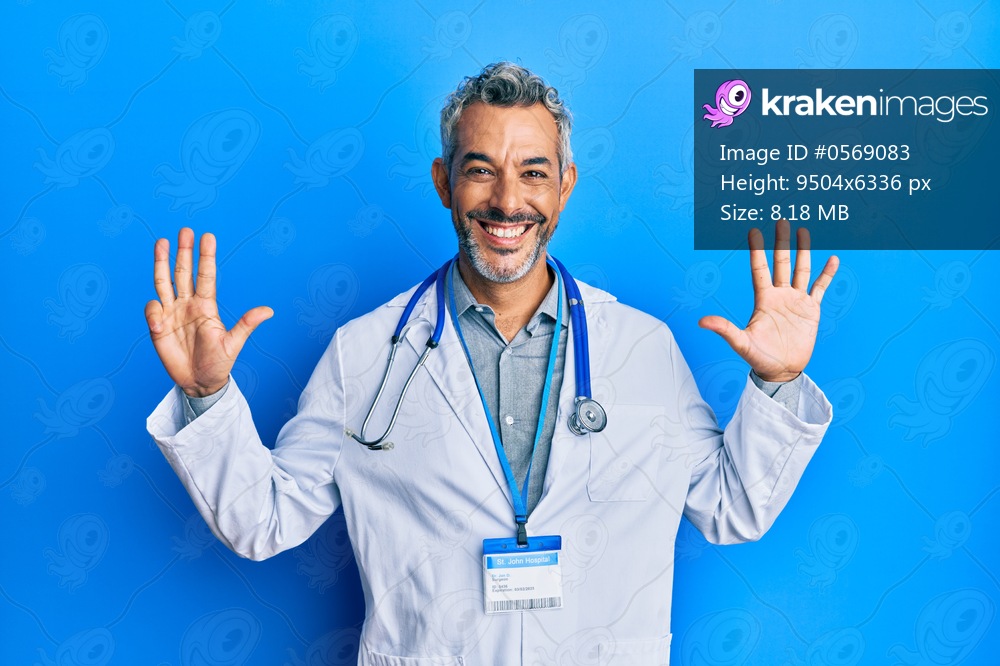 Middle age grey-haired man wearing doctor uniform and stethoscope showing and pointing up with fingers number nine while smiling confident and happy. 