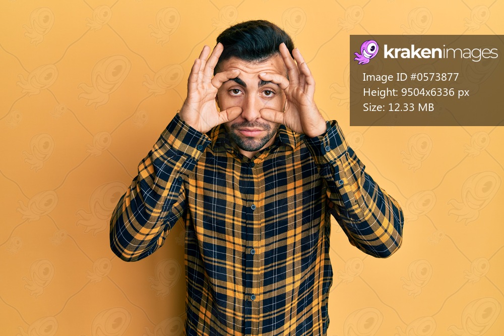 Young hispanic man wearing casual clothes trying to open eyes with fingers, sleepy and tired for morning fatigue 