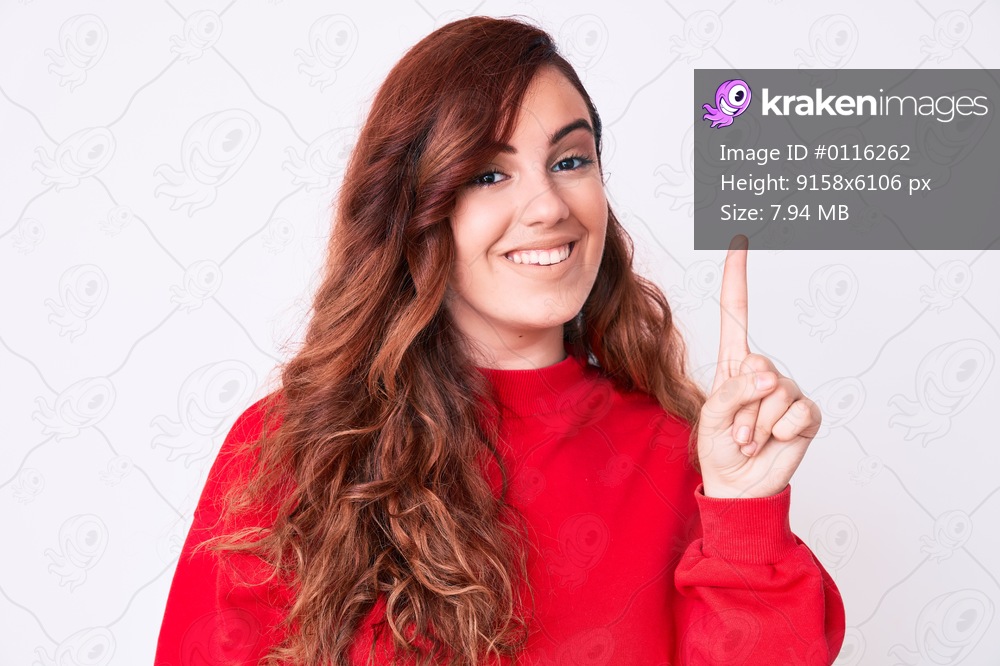 Young beautiful woman wearing casual clothes showing and pointing up with finger number one while smiling confident and happy. 