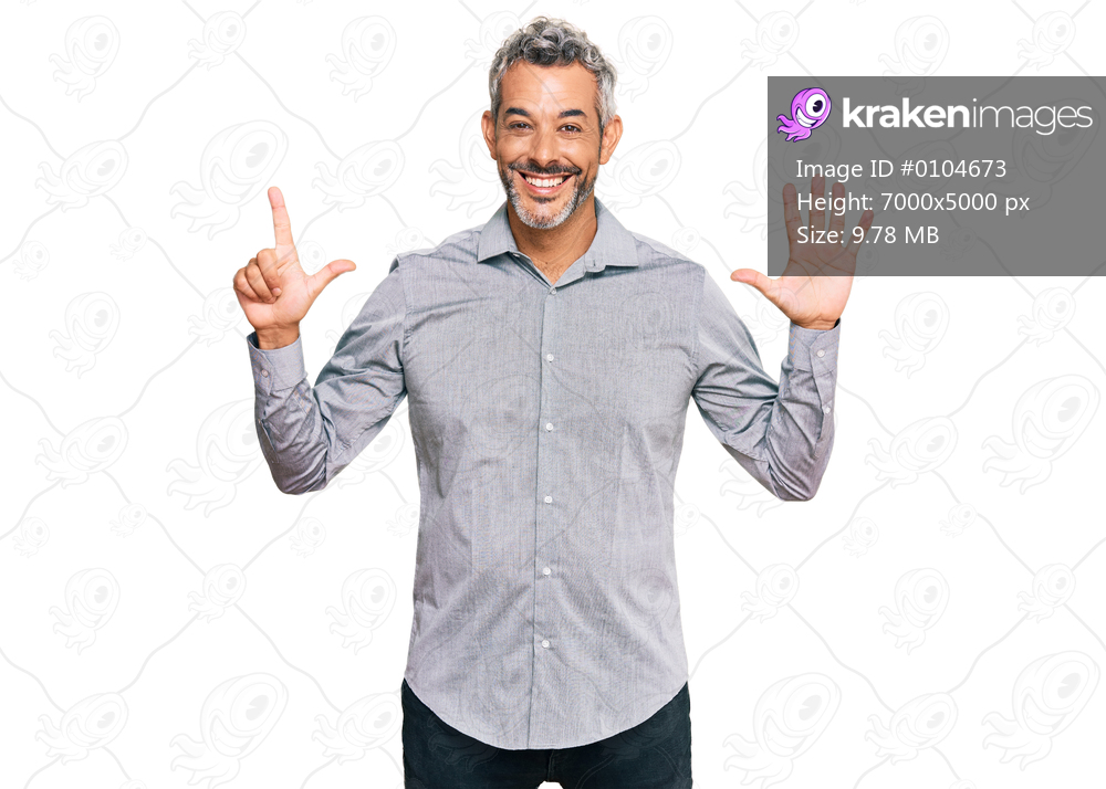 Middle age grey-haired man wearing casual clothes showing and pointing up with fingers number seven while smiling confident and happy. 