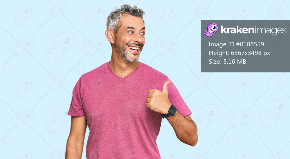 Middle age grey-haired man wearing casual clothes smiling with happy face looking and pointing to the side with thumb up. 