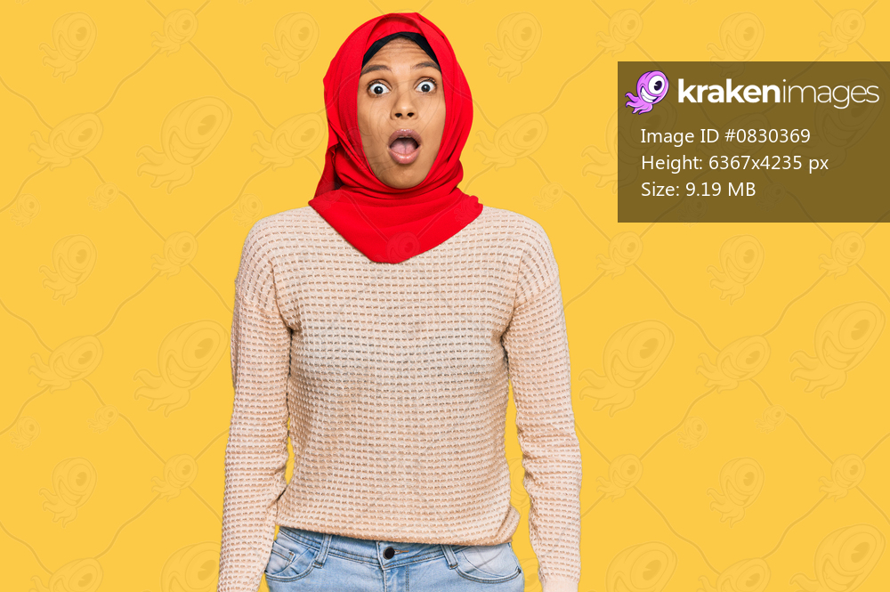 Young african american woman wearing traditional islamic hijab scarf afraid and shocked with surprise and amazed expression, fear and excited face. 