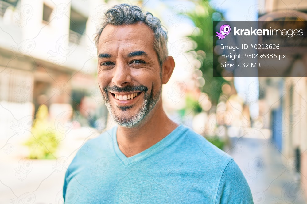 Middle age grey-haired man smiling happy walking at street of city.
